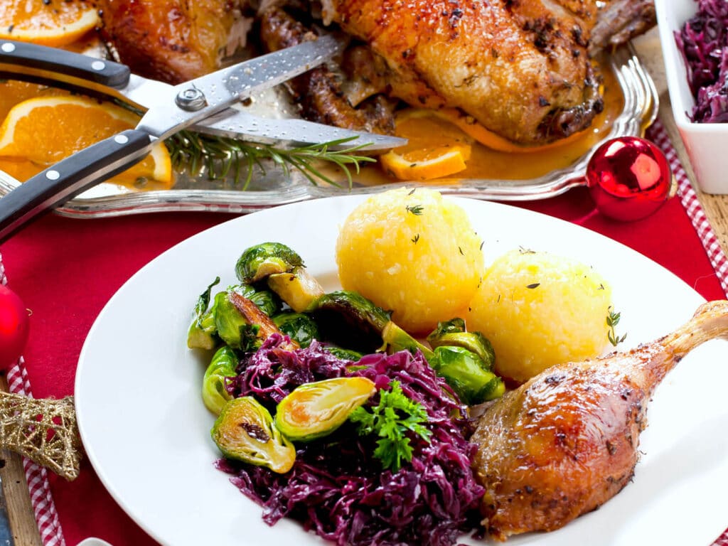 Ganz mit Klößen, Rotkohl und Rosenkohl auf einem Teller