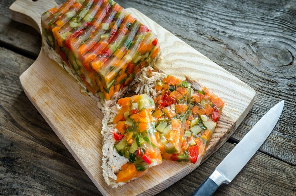 Hähnchen Sülze mit Gemüse auf einem Holzbrettchen